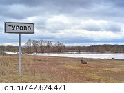 Разлившаяся река Лопасня у въезда в село Турово. Дорожный знак 5.23.1 «Начало населённого пункта». (2024 год). Стоковое фото, фотограф Владимир Литвинов / Фотобанк Лори