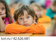 Boy with orange shirt at school desk. Стоковое AI-изображение, AI-художник Данил Руденко / Фотобанк Лори