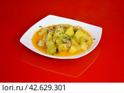 Тушенная картошка с мясом в белой тарелке на красном зеркальном фоне. Стоковое фото, фотограф Михаил Киселев / Фотобанк Лори