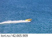BAIKAL LAKE, OLKHON ISLAND, SAKHYURTA VILLAGE, IRKUTSK REGION, RUSSIA - August 14, 2023: Tourists ride a motor boat on the blue water of the Small Sea on a sunny summer day. Редакционное фото, фотограф Виктория Катьянова / Фотобанк Лори