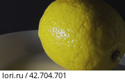 A ripe large yellow lemon rotates on a plate on a dark background. Food shooting. Стоковое видео, видеограф Ярославский Максим / Фотобанк Лори