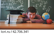 A high school student sleeps on a desk in the classroom. Стоковое фото, фотограф Mikhail Davidovich / Фотобанк Лори