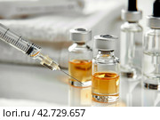 Beauty injections. Bottles, ampoules, cosmetics, fillers for cosmetic injections, syringe for injections, white towels. Стоковое AI-изображение, AI-художник Ольга Яковенко / Фотобанк Лори