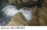 Поток чистой воды в горном каньоне. Крупный план. Камера снимает бурлящую воду, падающую с бревна. Вода пенится и бурлит, брызги разлетаются в разные стороны. Стоковое видео, видеограф Воловодов Владимир / Фотобанк Лори