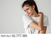 Woman with pain in shoulder, upper arm. Human body health problem banner. Female person is enduring awful ache. Upset lady with muscle, nerve pain symptoms holding a hand on painful zone injured point. Стоковое AI-изображение, AI-художник Марина Демидюк / Фотобанк Лори