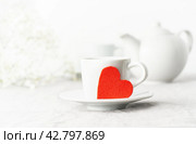 Valentine's Day. Morning breakfast for two with tea and flowers. Red felt heart is symbol of lovers. Стоковое фото, фотограф Natalia Gdovskaia / Фотобанк Лори