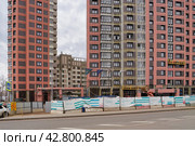 Окна и стены домов новостроек на завершающей стадии строительства. Район Крюково в Зеленограде. Дорога, ограждение. Заказчик: Московский фонд реновации жилой застройки. Генподрядчик: ООО "Альтстрой". (2024 год). Редакционное фото, фотограф Сергей Никифоров-Гордеев / Фотобанк Лори
