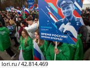 Участники космического шествия держат плакат с портретом Юрия Гагарина в день космонавтики 12 апреля на ВДНХ в городе Москве, Россия (2024 год). Редакционное фото, фотограф Николай Винокуров / Фотобанк Лори