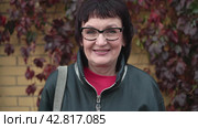 Portrait of a beautiful middle-aged female retirement age woman putting on glasses, enjoying successful lifestyle. Стоковое видео, видеограф EStarodubov / Фотобанк Лори