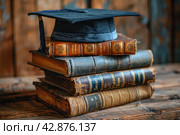 A stack of old books topped with an academic square beret with a tassel, which symbolizes the achievement of academic heights and learned traditions. Стоковое AI-изображение, AI-художник Анна Кривицкая / Фотобанк Лори