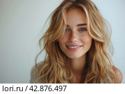 Young woman with delicate features. She has long blonde hair, slightly curly, and sea green eyes, full of warmth and light. Her skin appears flawless and has a soft glow. On the lips there is an unobtrusive shade of lipstick that harmonizes with the overall warm tone of the image. She looks at the viewer with a slight smile, creating a feeling of calm and friendliness. Стоковое AI-изображение, AI-художник Анна Кривицкая / Фотобанк Лори