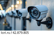 The CCTV camera is securely installed on the wall of the building. Стоковое AI-изображение, AI-художник Юрий Поздников / Фотобанк Лори