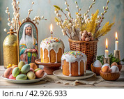 Orthodox Easter. Easter cake, painted eggs, icons, faces of saints, flowers, church candles and Easter decor on a wooden table in an old village house. Стоковое AI-изображение, AI-художник Photojuli / Фотобанк Лори