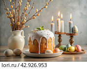 Orthodox Easter. Easter cake, painted eggs, icons, faces of saints, flowers, church candles and Easter decor on a wooden table in an old village house. Стоковое AI-изображение, AI-художник Photojuli / Фотобанк Лори