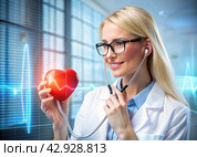 Medicine a young beautiful girl is a cardiologist with glasses in an office with a stethoscope. Red numeric codes in the form of a heart rhythm on a virtual screen. Digital technologies of the future. Стоковое AI-изображение, AI-художник Photojuli / Фотобанк Лори