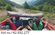 SUV driving on gravel road and streams in the mountains. First-person view of saloon with people and driver. High mountains and glaciers ahead. Off-road journey. Russia June 2, 2023. Редакционное видео, видеограф Воловодов Владимир / Фотобанк Лори