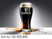 Glass of Guinness beer on a gray background. Стоковое AI-изображение, AI-художник Александр Довянский / Фотобанк Лори