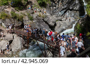 ARSHAN VILLAGE, TUNKINSKIY DISTRICT, BURYATIA, RUSSIA -  August 12, 2023: Many tourists came to popular waterfall on mountain river Kyngarga - natural landmark of Tunkinskiy Park reserve. Редакционное фото, фотограф Виктория Катьянова / Фотобанк Лори