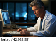 Experienced adult male doctor working at a desk on a computer in his office in the evening. Стоковое AI-изображение, AI-художник Александр Довянский / Фотобанк Лори