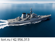 Aerial top view of modern warship sailing in still water at blue sky, mission military control of sea. Battleship on protection of water state borders. Naval forces army concept. Copy ad text space. Стоковое AI-изображение, AI-художник Aleksandr Golubev / Фотобанк Лори