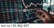A banner with a hand holding a bitcoin coin on the background of a screen with an exchange rate chart. Стоковое AI-изображение, AI-художник Ярославский Максим / Фотобанк Лори