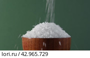 White table salt granules falling into a pile. Wood bowl. Gray color studio background. Condiment particles dropping. Clean cosmetic bath salt pouring footage. Closeup of grained sea salt pieces hill. Стоковое видео, видеограф Марина Демидюк / Фотобанк Лори