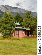 Buddhist datsan Bodhidharma in resort village of Arshan against background of Eastern Sayan Mountains on Tunkinskiy Natural Park Reserve on sunny summer day. Siberia, Baikal region, Buryatia (2022 год). Стоковое фото, фотограф Виктория Катьянова / Фотобанк Лори