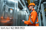 An engineer in highvisibility workwear is studying a tablet near an elevator. Стоковое AI-изображение, AI-художник Юрий Поздников / Фотобанк Лори