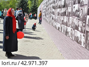 Пожилая женщина возле стены памяти. Город Тюмень (2016 год). Редакционное фото, фотограф Александр Тараканов / Фотобанк Лори