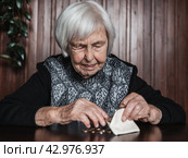 Portrait of an old woman counting money. The concept of old age, poverty, austerity. Стоковое фото, фотограф Matej Kastelic / Фотобанк Лори