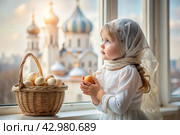 Happy bright Easter. Christianity. Portrait of a three-year-old girl in a Russian folk dress and shawl with a wicker basket with Easter eggs in her hands against the background of an Orthodox church. Стоковое AI-изображение, AI-художник Photojuli / Фотобанк Лори