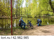 Воронцовский парк, Москва, Россия, Воронцовский пруд (2024 год). Два рыбака ловят рыбу, весна. Редакционное фото, фотограф Iva Noel / Фотобанк Лори