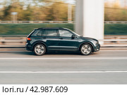Volkswagen Tiguan in the motion on the highway. VW SUV car drive on asphalt city road. Unacceptable speeding concept. Редакционное фото, фотограф Константин Григорьев / Фотобанк Лори