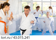 Woman is paired with man teacher to learn how to strike and rehearses blocking opponent. Стоковое фото, фотограф Яков Филимонов / Фотобанк Лори