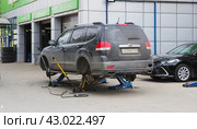 Легковой автомобиль стоит на подкатных домкратах у автомастерской. Липецк. (2024 год). Редакционное фото, фотограф Евгений Будюкин / Фотобанк Лори