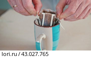 Drip bag fresh coffee. Pouring hot water into blue cup with drip coffee bag. Instant freshly brewed cup of ground coffee. Coffee Trend. Quick way to brew using paper filter. The process of brewing. Стоковое видео, видеограф Марина Демидюк / Фотобанк Лори
