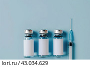 Syringe and glass vial on blue background flat lay. Medical Vials group, needles, ampoules, bottle with medicine, vaccine. Disease treatment. Creative Banner. Anti-aging beauty injections. Vaccination. Стоковое AI-изображение, AI-художник Марина Демидюк / Фотобанк Лори