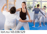 Woman hits man attacker on head during self-defense training session led by trainer. Стоковое фото, фотограф Яков Филимонов / Фотобанк Лори