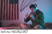 The guy is unable to play the game console due to his vision impairment, which requires him to wear glasses. Стоковое видео, видеограф Strunov David / Фотобанк Лори