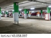 Пустая подземная парковка торгового центра.  Spacious underground parking of a modern shopping center. The parking lot is marked and has many free spaces for cars. Стоковое фото, фотограф Лариса Гордеева / Фотобанк Лори