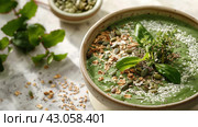 A plantbased recipe of green soup topped with nuts and seeds. Стоковое AI-изображение, AI-художник Юрий Поздников / Фотобанк Лори