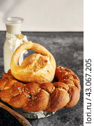 Assortment of white bread. Kalach and challah made of wheat flour on table with milk. Стоковое фото, фотограф Оксана Медведева / Фотобанк Лори