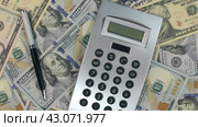 Вращение калькулятора и ручки, лежащих на долларах. Вид сверху. Rotation of the calculator and pen lying on the dollars. Стоковое видео, видеограф Александр Собко / Фотобанк Лори
