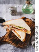 Club sandwich with chicken meat, tomato and lettuce on a board on the table vertical view. Стоковое фото, фотограф Елена Руй / Фотобанк Лори
