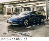 Автомобиль Porsche Taycan синего цвета стоит на парковке (2024 год). Редакционное фото, фотограф Константин Григорьев / Фотобанк Лори
