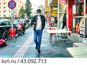 Antalya is in red zone for coronavirus, among security measures curfew and wearing face masks, young man uses PPE on city street. Стоковое фото, фотограф Владимир Григорьев / Фотобанк Лори