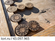 Старинные деревянные нарды ( деталь) крупным планом. Игры во дворе, на улице./ Old wooden backgammon. Backgammon chips close-up on the board. Стоковое фото, фотограф Iva Noel / Фотобанк Лори