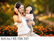 Happy woman with little boy in headphones sit in park. Стоковое фото, фотограф Владимир Григорьев / Фотобанк Лори