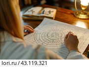 An astrologer compiles and studies a natal chart for his client, astrology, astrological signs. Стоковое AI-изображение, AI-художник Ольга Ильина / Фотобанк Лори