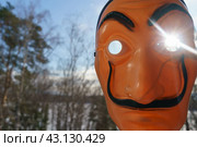 Moscow region, Russia - March 17, 2023: Photography of the Salvador Dali mask peeps in your window. Sunny futuristic day. He looks like smiling man. Sun in his eye. Close up photography. Редакционное фото, фотограф YuryKara / Фотобанк Лори